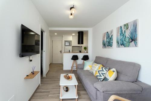 a living room with a gray couch and a table at Estrella de Mar in Torrox Costa