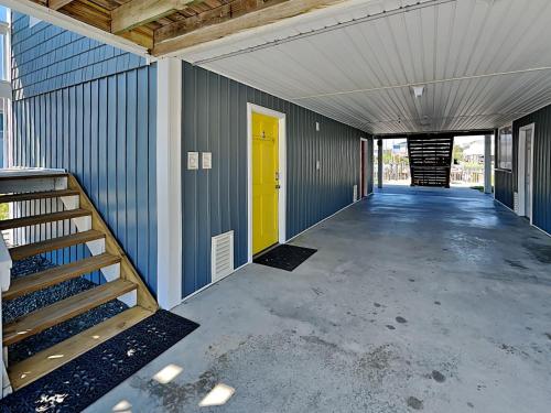 an empty garage with a yellow door and stairs at On Island Time in Topsail Beach