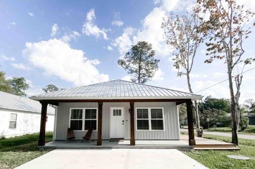 a small white shed with a pitched roof at Cottage Marhome North - 10 min from beach & historic downtown in Saint Augustine