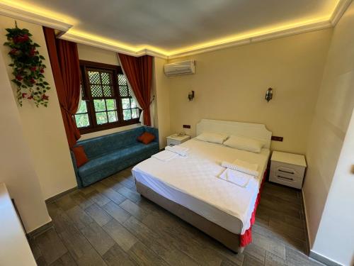 a small bedroom with a bed and a couch at Kaliptus Hotel in Kemer