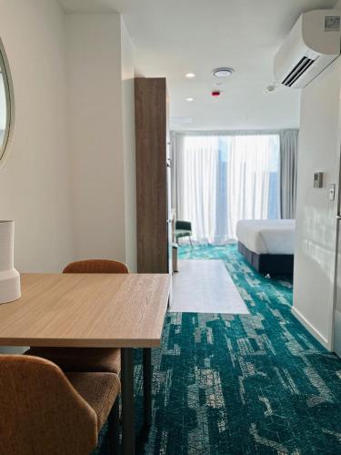 a hotel room with a bed and a table and chairs at La Quinta by Wyndham Ellerslie Auckland in Auckland