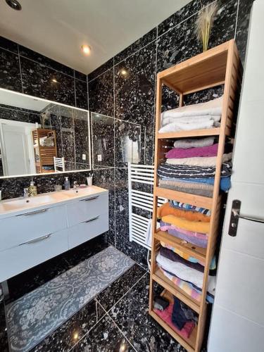 une salle de bain avec un lavabo et une étagère avec des serviettes dans l'établissement Belle maison 3 chambres 3min des plages de Juan les pins 8personnes, à Antibes