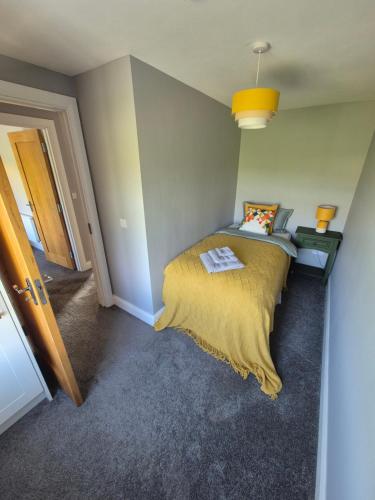 a bedroom with a bed with a yellow blanket at River View Apart Doolin in Doolin