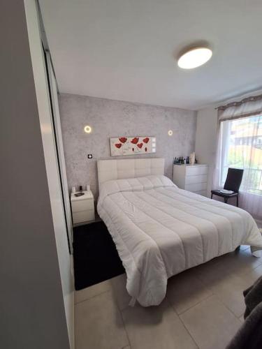 une chambre avec un grand lit blanc et une fenêtre dans l'établissement Belle maison 3 chambres 3min des plages de Juan les pins 8personnes, à Antibes