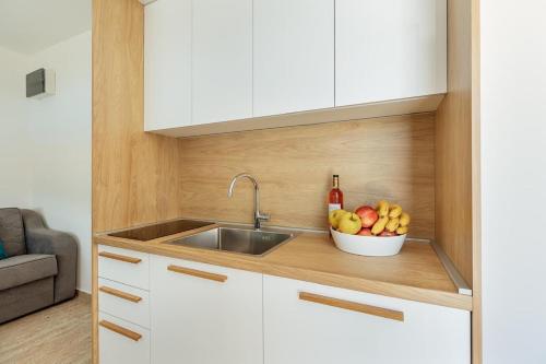 a kitchen with a sink and a bowl of fruit at Bella Vista Luxure Apartments in Baošići