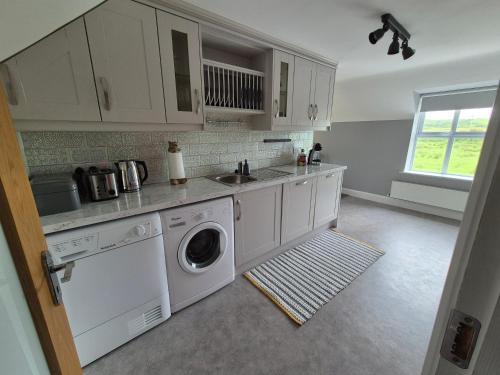 a kitchen with a washing machine and a sink at River View Apart Doolin in Doolin