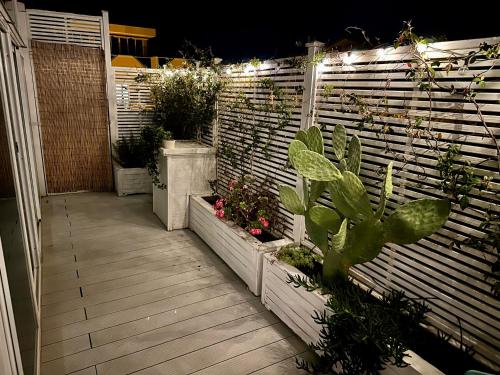 a patio with plants and a fence with lights at ROOFTOP-MarinaCentro-Unique-Beach-Fun-Smart-LoveApt-Train-Park in Rimini