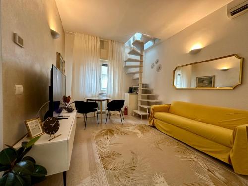 a living room with a yellow couch and a table at ROOFTOP-MarinaCentro-Unique-Beach-Fun-Smart-LoveApt-Train-Park in Rimini