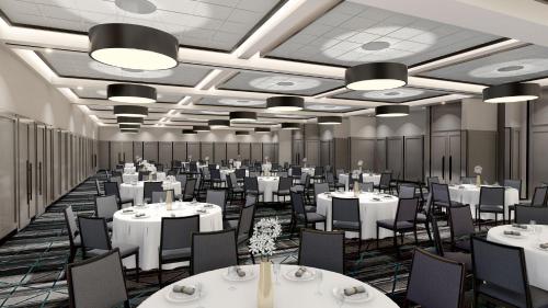 a banquet hall with white tables and chairs at Holiday Inn St-Jean-sur-Richelieu Congrès by IHG in Saint-Jean-sur-Richelieu