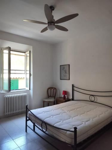 Un dormitorio con una cama con ventilador de techo. en Appartamento vacanze Piombino, en Piombino