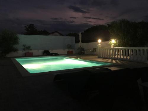 une piscine dans une cour la nuit dans l'établissement Gîte coteaux de Montcuq - 4 personnes, à Belvèze