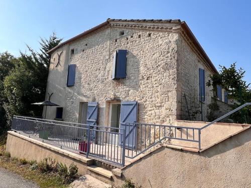 un bâtiment avec un balcon et une horloge dessus dans l'établissement Gîte coteaux de Montcuq - 4 personnes, à Belvèze