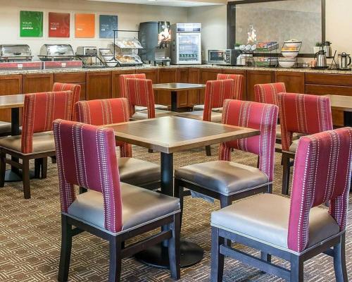 a restaurant with tables and chairs and a counter at Bluffton Inn & Suites in Bluffton