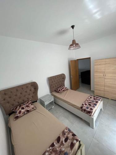 a living room with two beds and a couch at Residence bellevue in Menzel Jemil