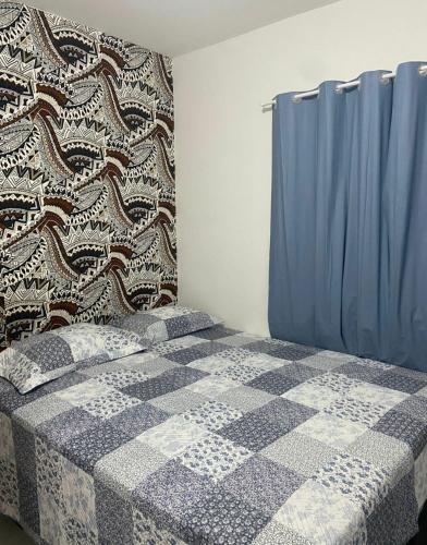 a bedroom with a bed with a blue curtain at Quarto Super King com Ar in Imperatriz