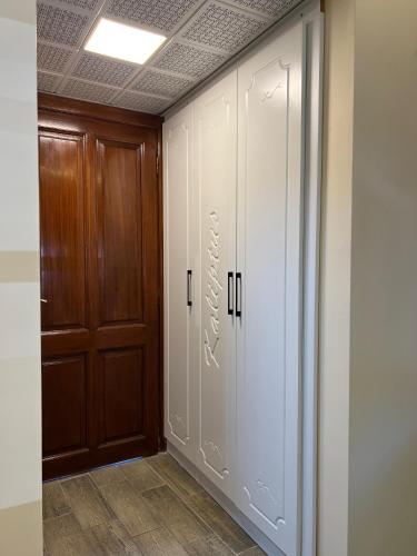 a hallway with white cabinets and a door at Kaliptus Hotel in Kemer