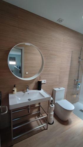 a bathroom with a sink and a mirror and a toilet at Casa Abuela Ángela in Granja de Moreruela