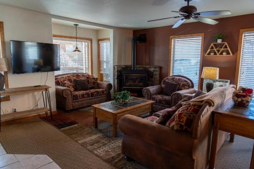 a living room with couches and a flat screen tv at Alpenglow Three Bedroom Two Bath XL – A16 in Ouray