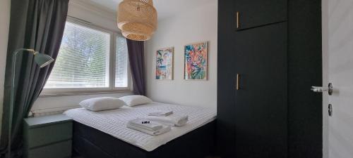 Un pequeño dormitorio con una cama con toallas. en Pietarsaaren Helmi, en Jakobstad