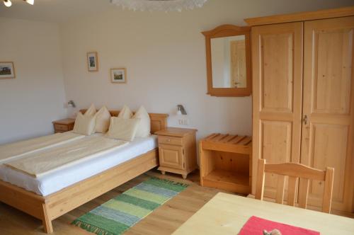 1 dormitorio con 1 cama y armario de madera en Biobauernhof Wolf-Hof, en Pressbaum