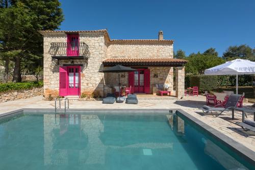 a villa with a swimming pool in front of a house at Aresti Mountain Resort in Agios Leon