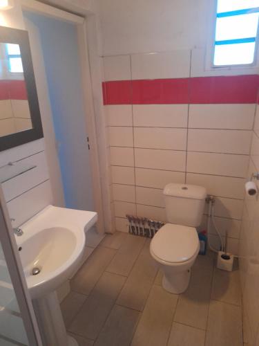 une salle de bains avec des toilettes blanches et un lavabo dans l'établissement Sunset, à Sainte-Anne