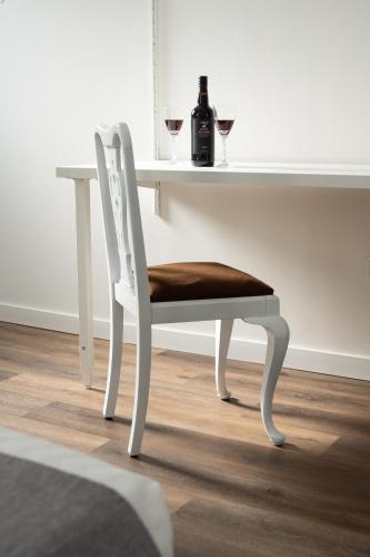 a white chair with a table with a bottle of wine at Casa da FÁ 2 in Pinhão
