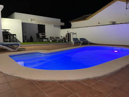 a large blue swimming pool in a yard at Ilusión Vejer in El Soto