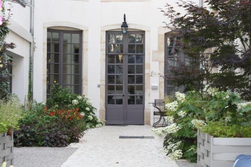 a front door of a house with flowers at Hotel De Guise Nancy Vieille Ville in Nancy