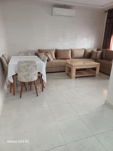 a living room with a couch and a table at Appartement entier avec piscine in Mohammedia