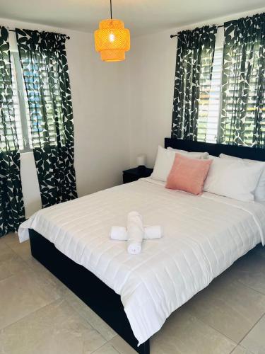 a bedroom with a large bed with two towels on it at Villas Boqueyé in Cabo Rojo