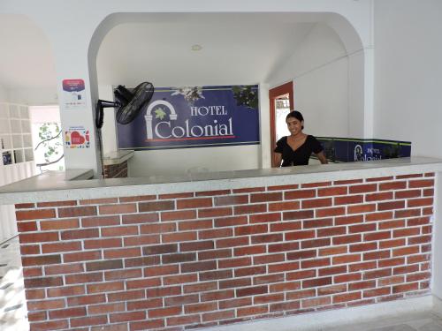 una mujer parada en el mostrador de un hotel colonial en HOTEL COLONIAL en Barrancabermeja