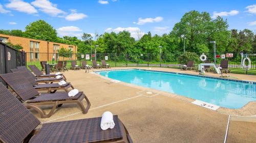 a swimming pool with chaise lounges and chairs at Best Western Leesburg in Leesburg