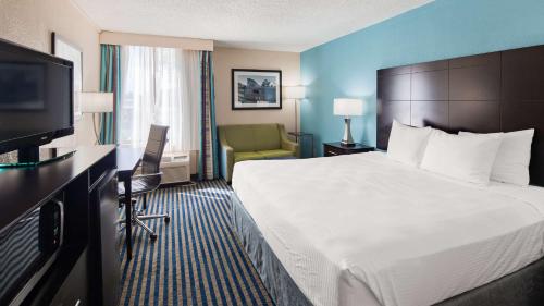 a hotel room with a bed and a flat screen tv at Best Western Leesburg in Leesburg