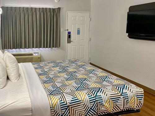 una camera da letto con un grande letto e un piumone colorato di Motel 6-Huntington, WV a Huntington