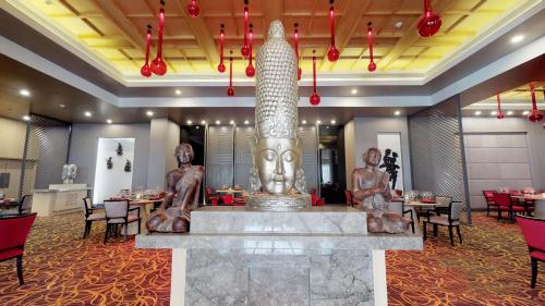 a restaurant with a large statue in the middle of a room at Radisson Blu Bengaluru Outer Ring Road in Bengaluru