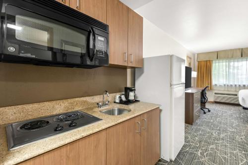 eine Küche mit einer Spüle und einer Mikrowelle in der Unterkunft Best Western West Towne Suites in Madison