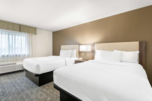 a hotel room with two beds and a window at Best Western West Towne Suites in Madison