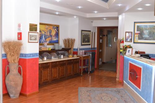a living room with a table and a vase at Hotel Aurora in Tivoli Terme