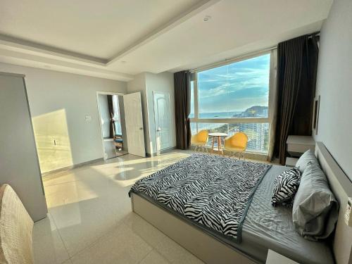 a bedroom with a zebra print bed and a large window at Nice Oasky Apartment Ocean Key 502 in Vung Tau
