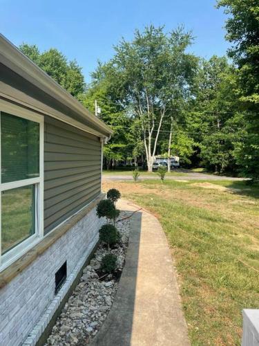 a house with a yard next to a building at Serenity away from the big city in Amelia