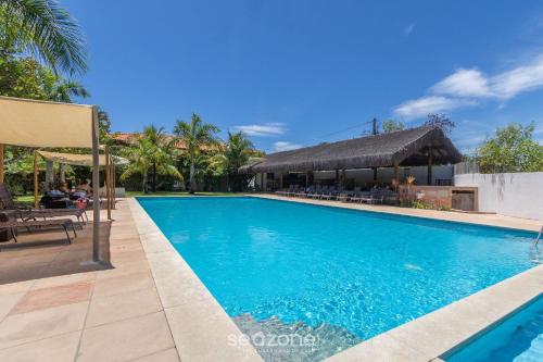 a swimming pool at a resort with a restaurant at TPZ's - Apartamentos próximos da Praia do Mutá in Porto Seguro