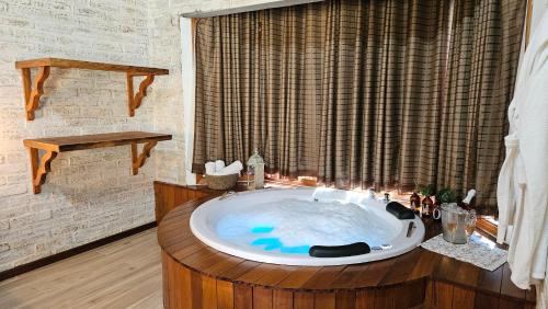 uma casa de banho com uma grande banheira e uma janela em Chalé Gosto da Roça em Monte Verde
