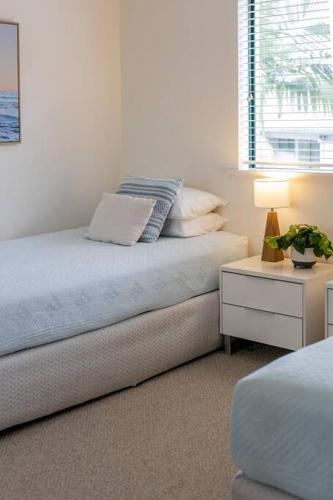 a bedroom with a bed and a table with a lamp at Charming Riverside Noosa gem in Noosaville