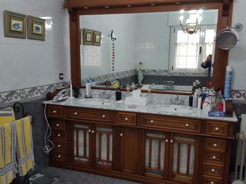 a bathroom with a sink and a large mirror at Casa Rural Villa Ronquillo a 2 k m de las playas in San Pantaleon