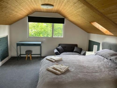 a bedroom with a bed and a desk and a window at Brambles, Ebford, Devon in Exeter