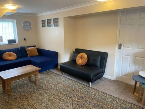 a living room with a blue couch and a chair at Brambles, Ebford, Devon in Exeter