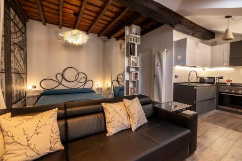 a living room with a leather couch and a kitchen at Alloggio Fronte Egizio in Turin