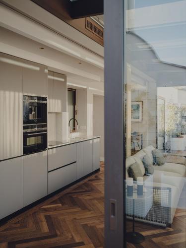 a kitchen with white cabinets and a living room at Madrid 1915 Private Suites in Madrid