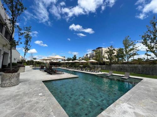 a swimming pool with benches and umbrellas at casa Nirvana in San Miguel de Allende